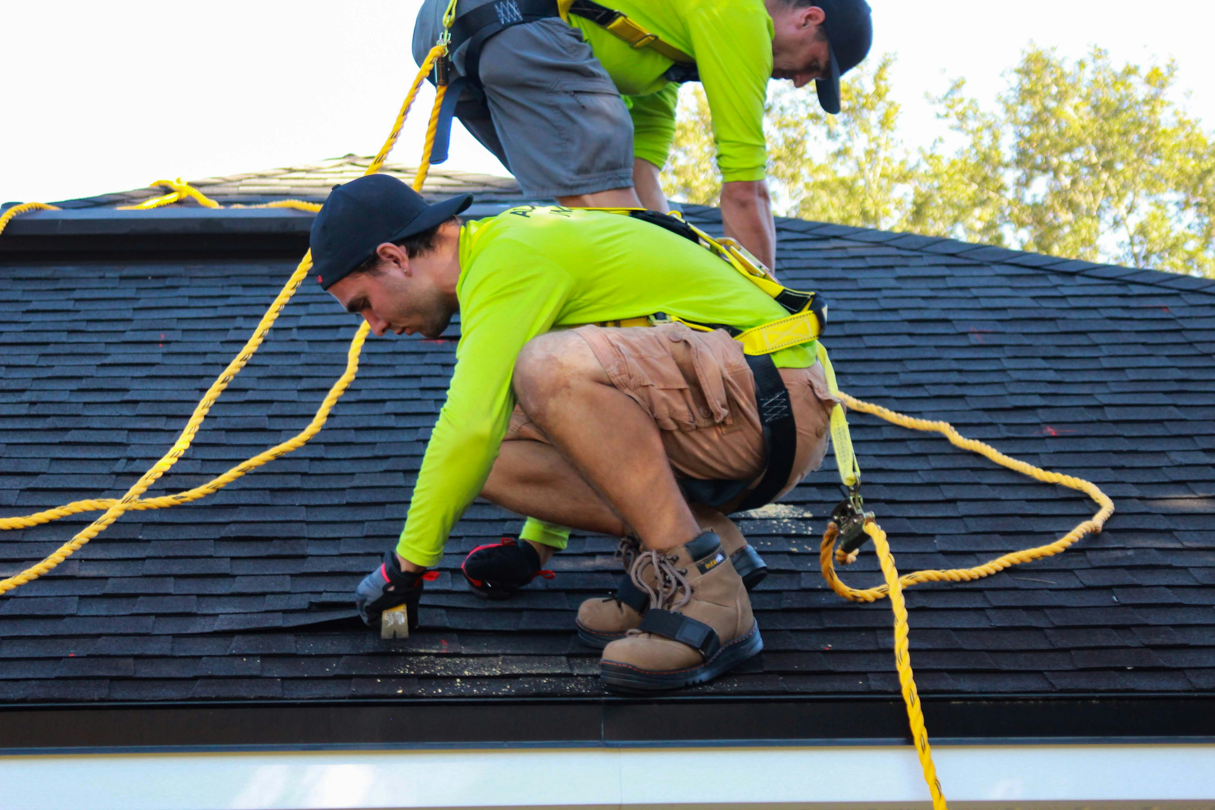 Two Men Repairing A Roof